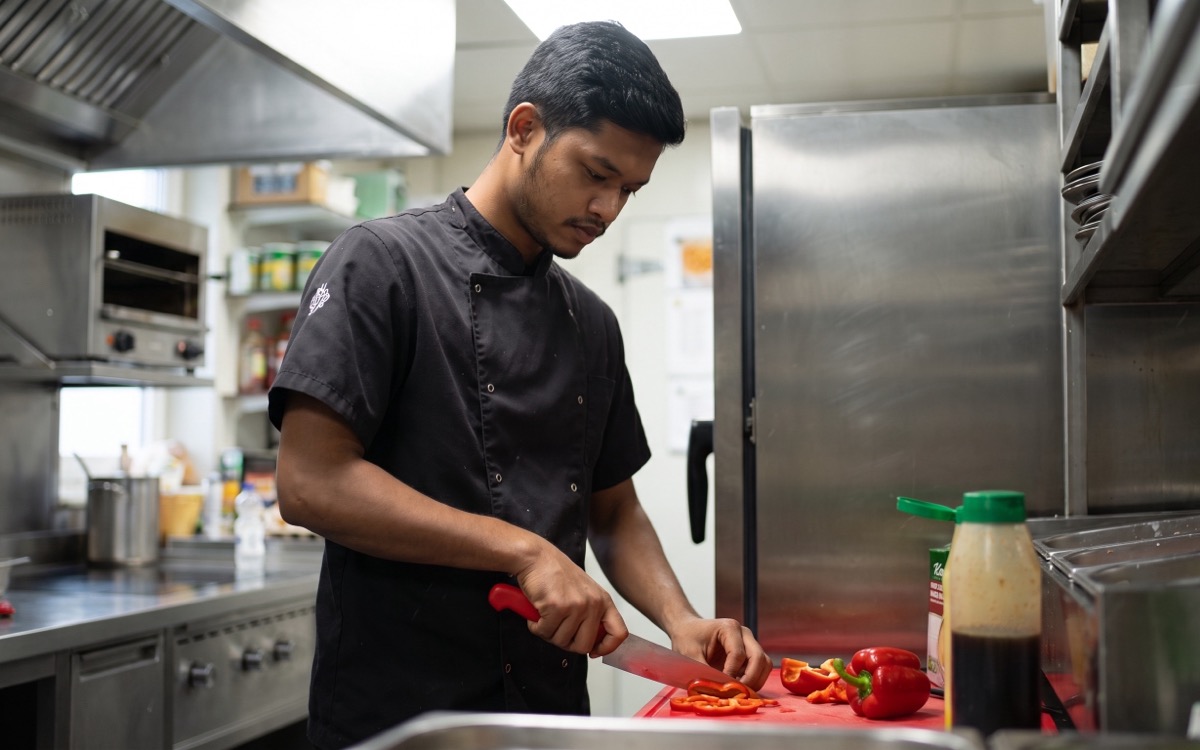 Freelance chef Shoikot preparing peppers in a professional kitchen